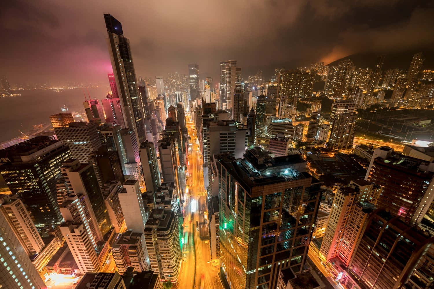Beautiful City 桌布 壁紙 — 夜晚密集城市景觀的鳥瞰圖，發光的摩天大樓和流動的交通燈照亮了城市峽谷。