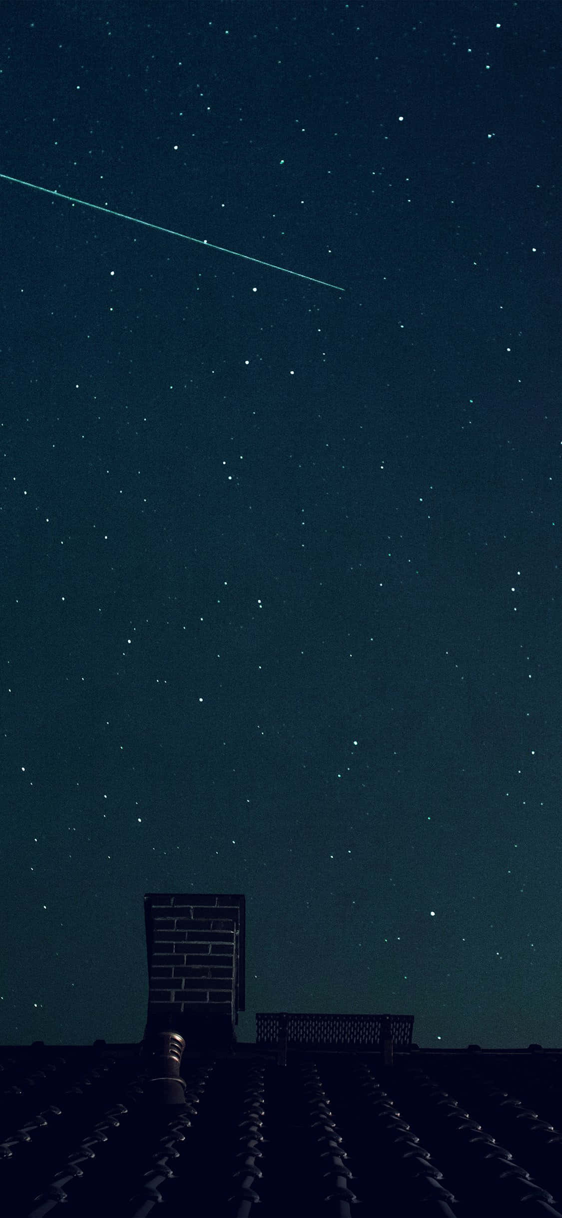 夏天 iPhone 桌布 壁紙 — 夜晚屋頂，星空下，一顆明亮的流星劃過深藍色的天空。
