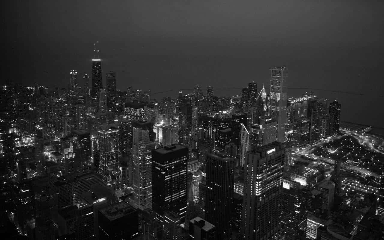 黑白風格 桌布 壁紙 — 夜晚廣闊城市景觀的黑白航拍圖， featuring 燈火通明的摩天大樓和發光的街道。