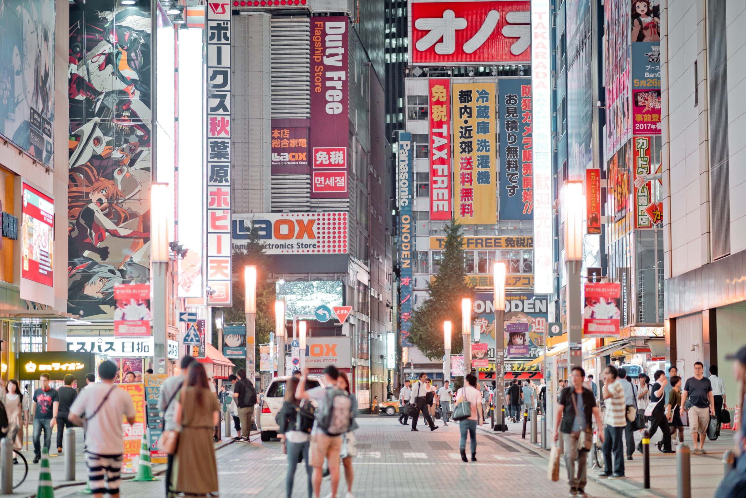 Otaku Culture 桌布 壁紙 — 夜晚東京繁華的街道，霓虹燈牌、動漫廣告板，人群在燈光下行走。