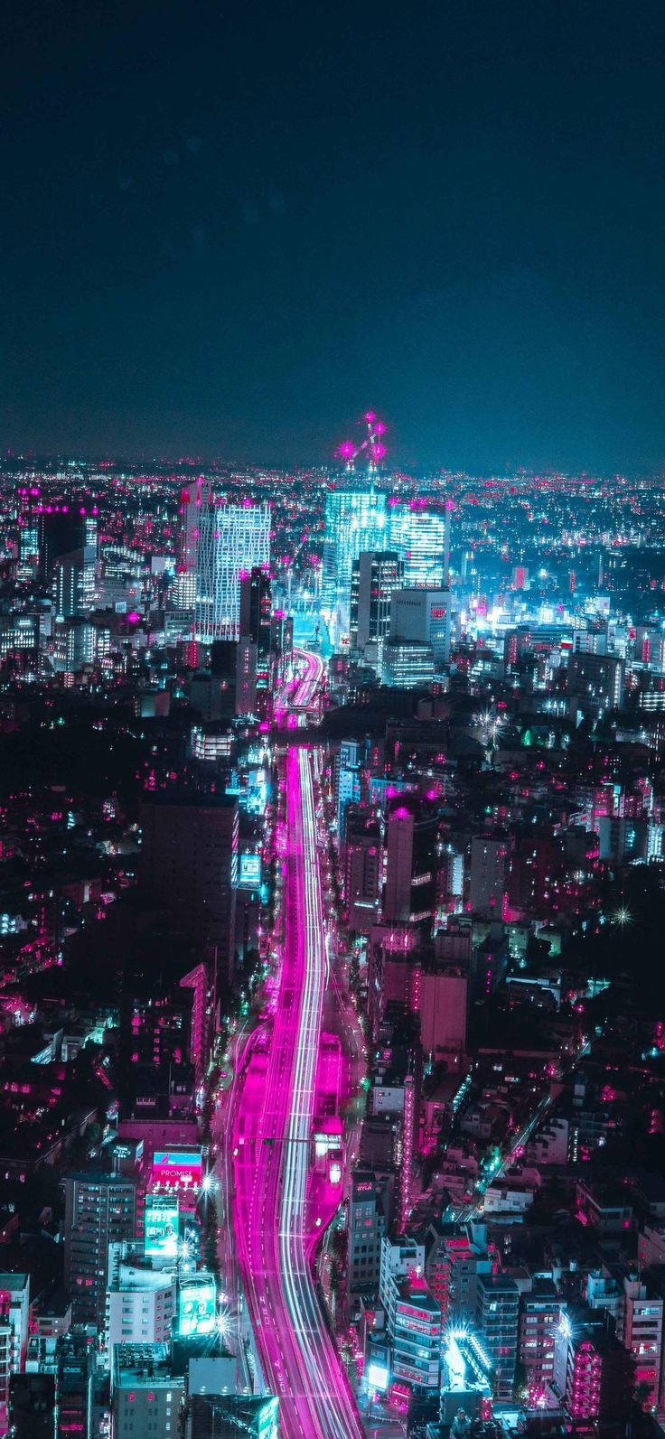 Cityscape 桌布 壁紙 — 夜晚被霓虹燈淹沒的城市鳥瞰圖，發光的粉紅色和藍色燈光照亮了高聳的建築物和充滿活力的高速公路。