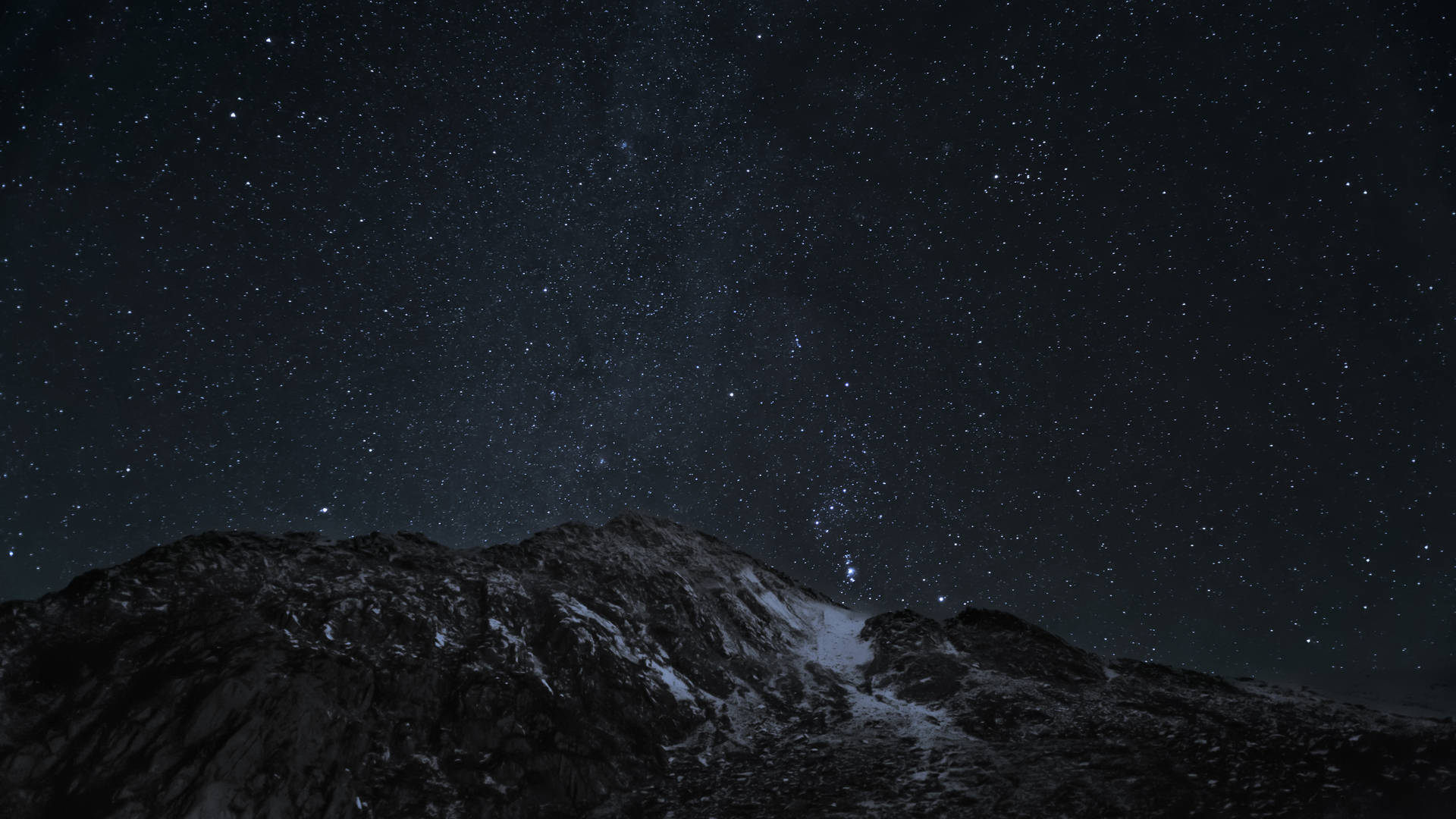 在繁星點點的夜空下，積雪的山峰。