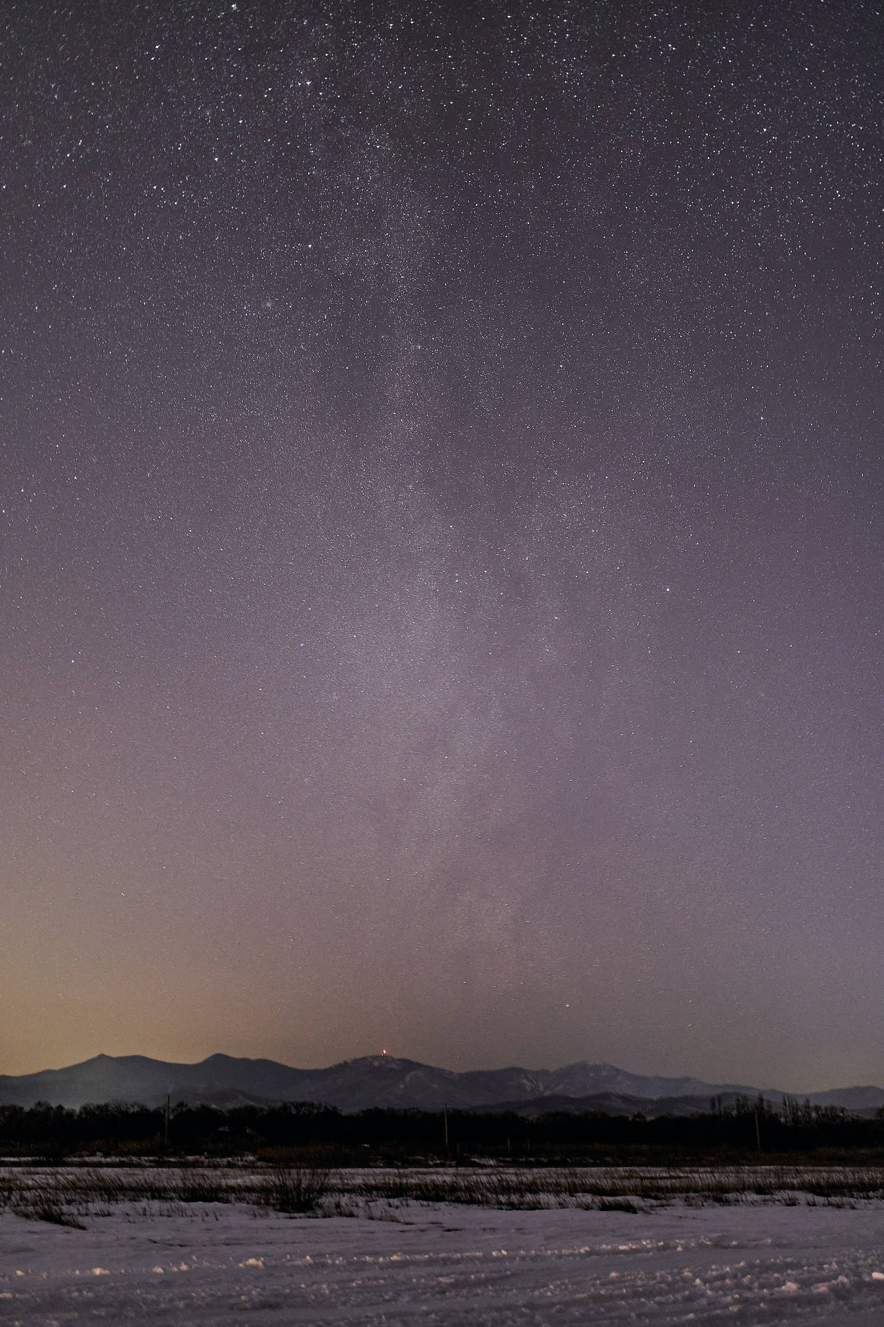 雪地田野，星空下，銀河拱跨遠山