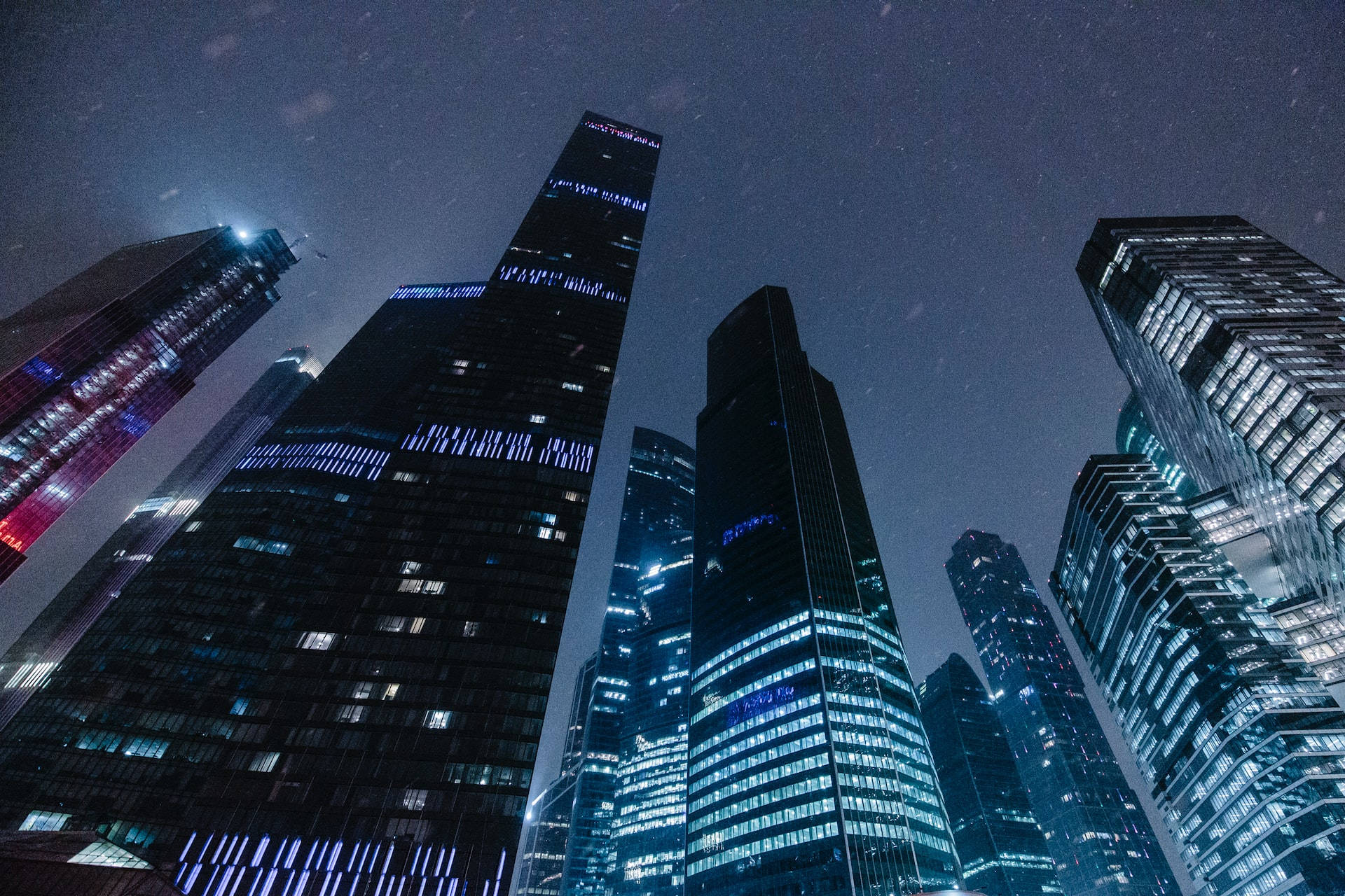 雪天下，燈火通明的摩天大樓夜景。