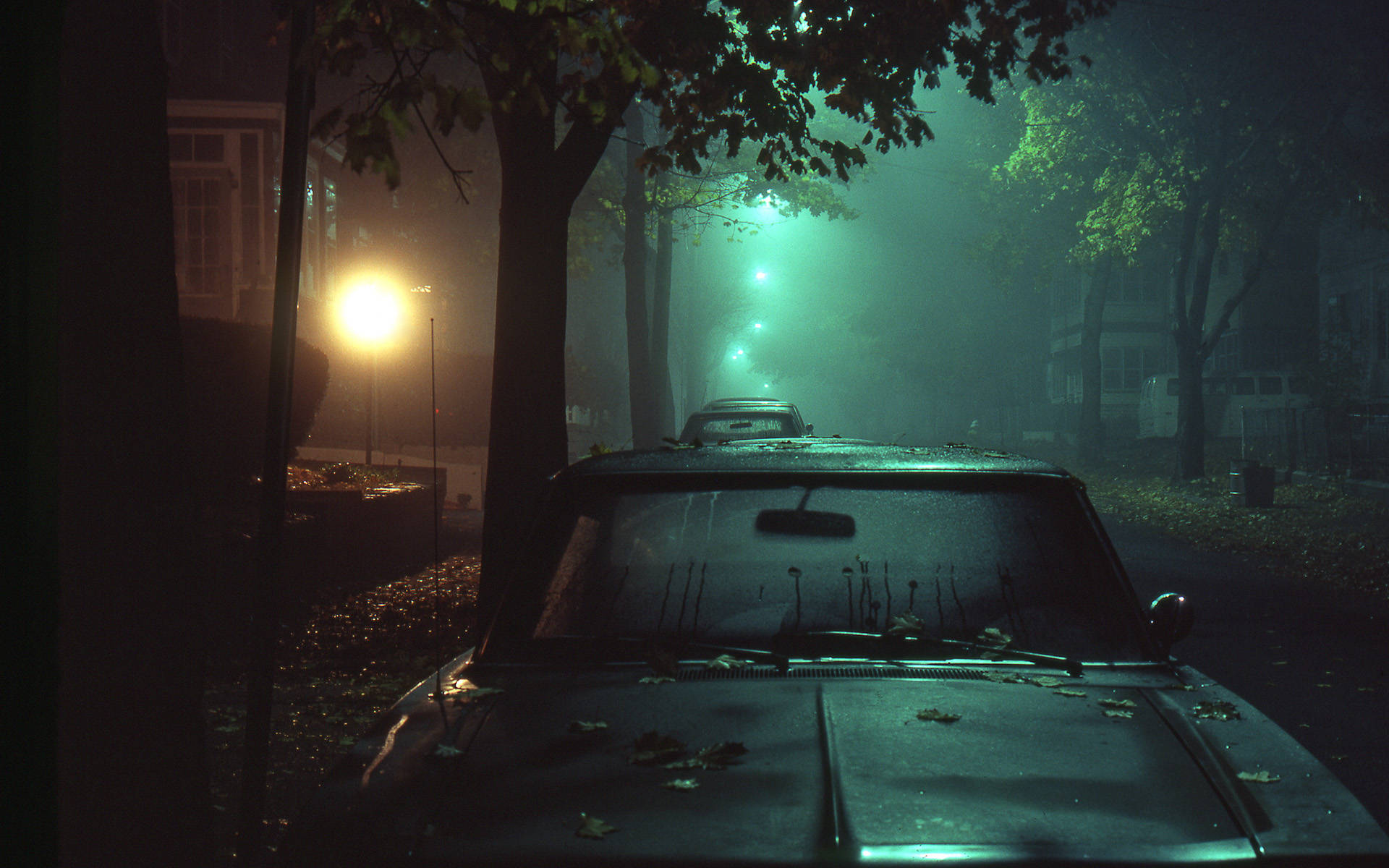 夜晚霧氣瀰漫的街道上被遺棄的老爺車，街燈閃爍。