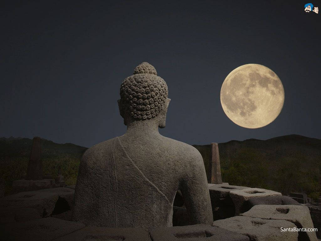 石佛像面向夜間山景上的滿月。