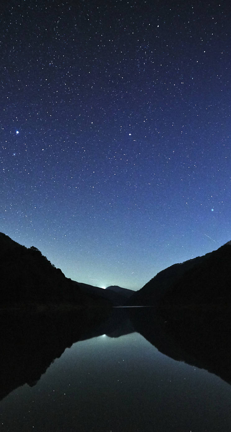 星空夜空倒映在寧靜的山湖中。