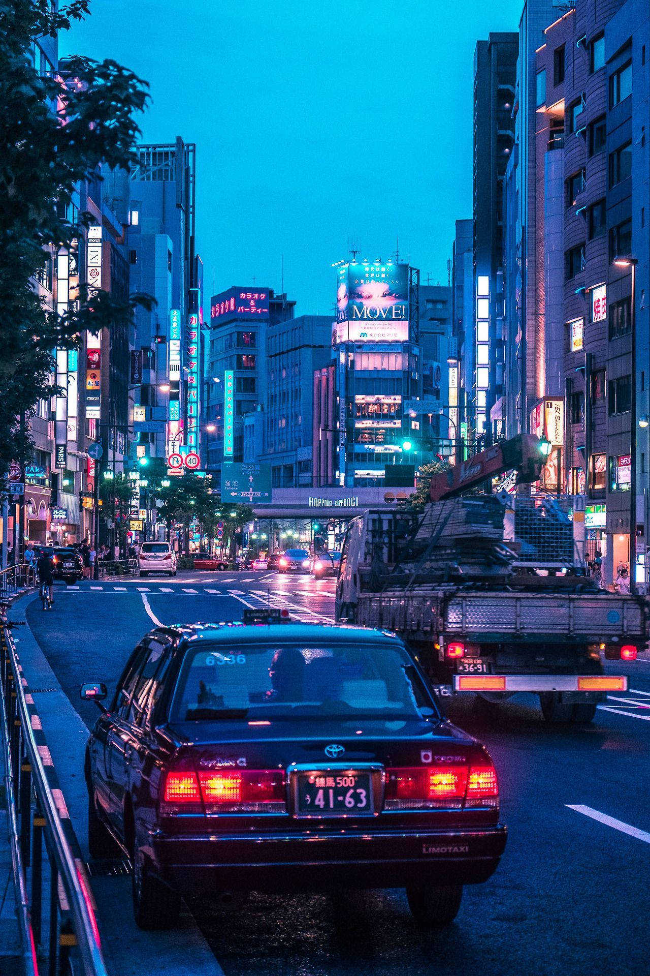 黃昏的東京街道，霓虹燈招牌和汽車在潮濕的路面上