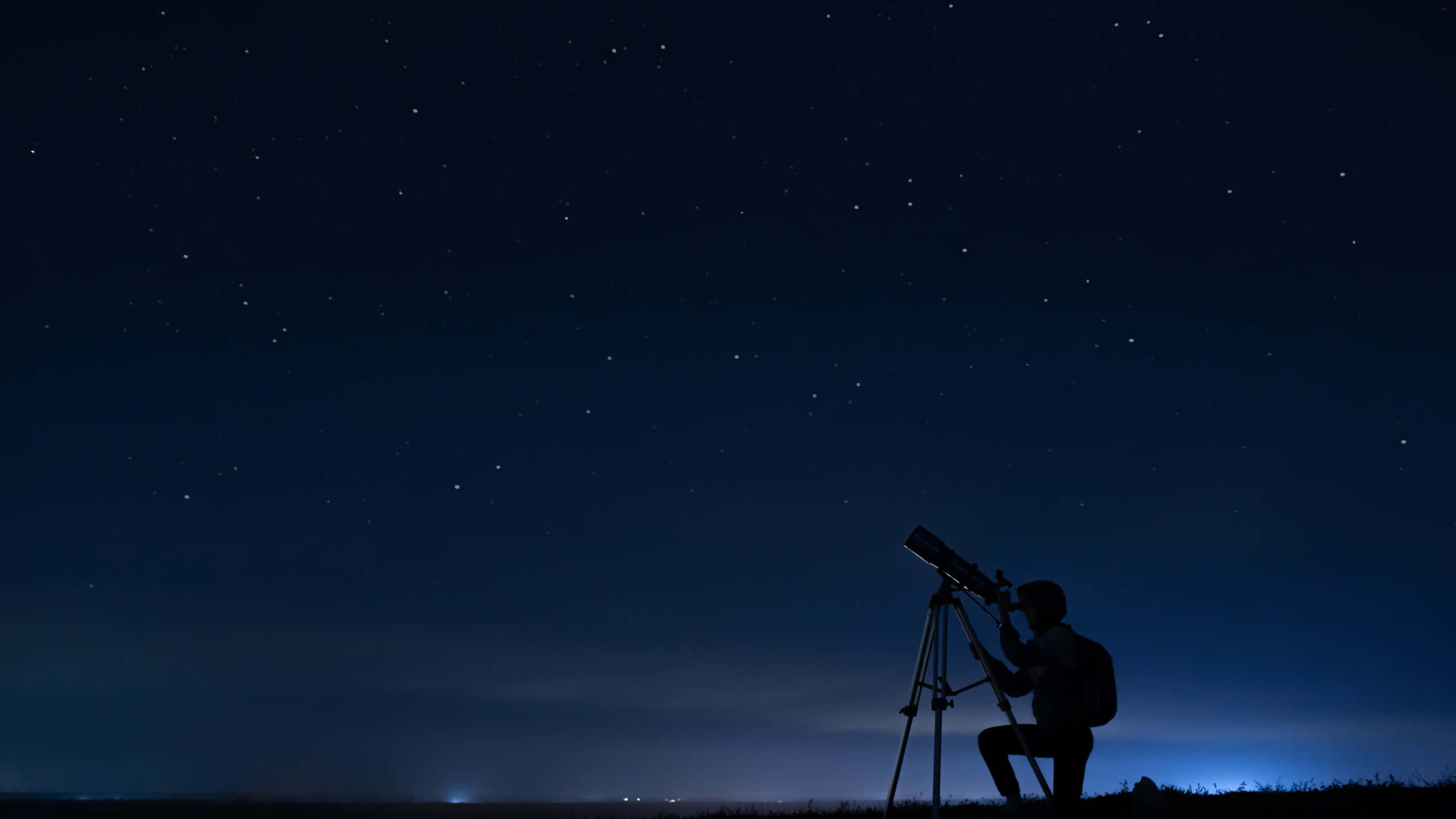 夜空下持望遠鏡的男性剪影天文學 壁紙 — 一個人在廣闊的星空下跪著使用望遠鏡的剪影。