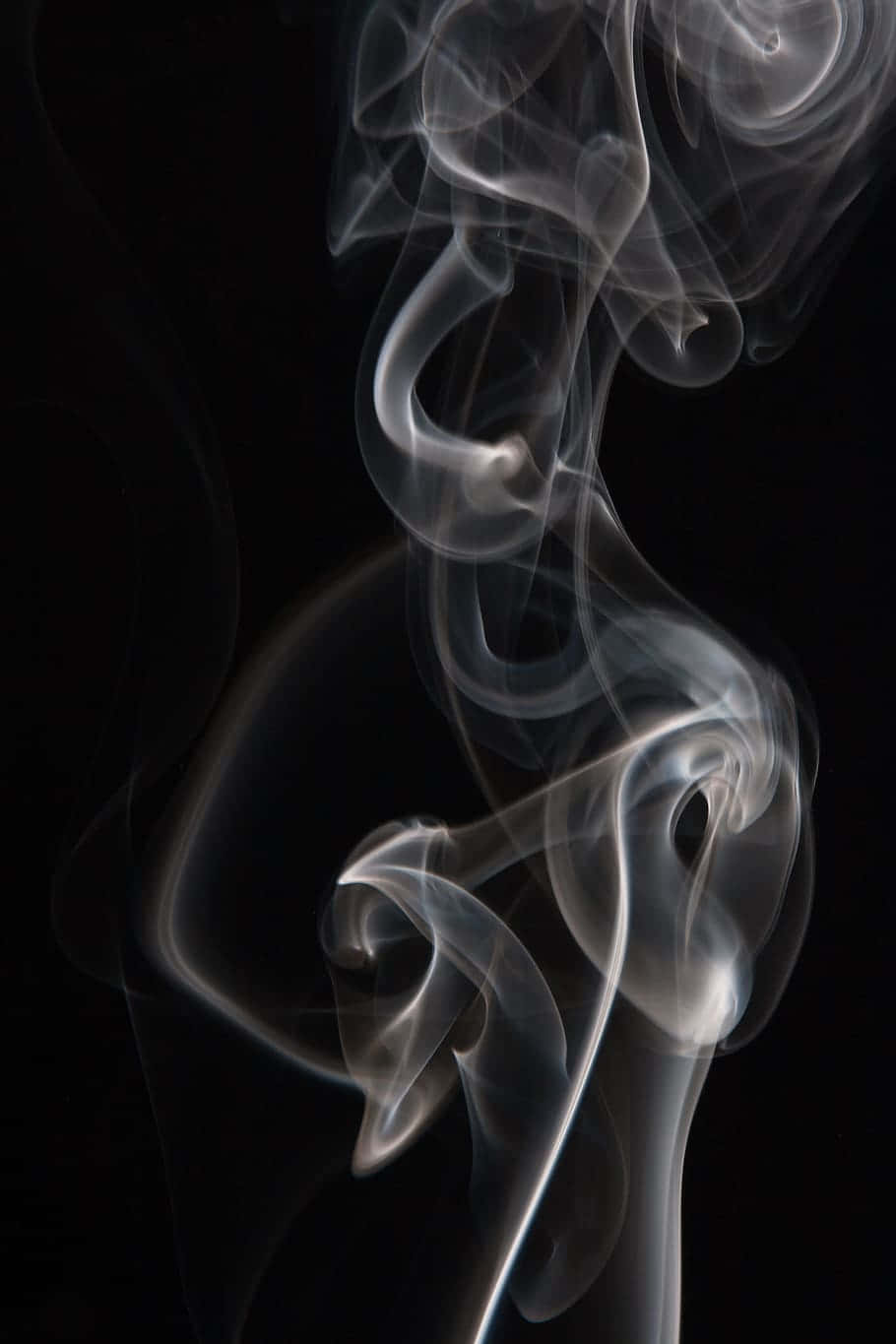 黑色背景上優雅旋轉的俏皮煙霧圖案。