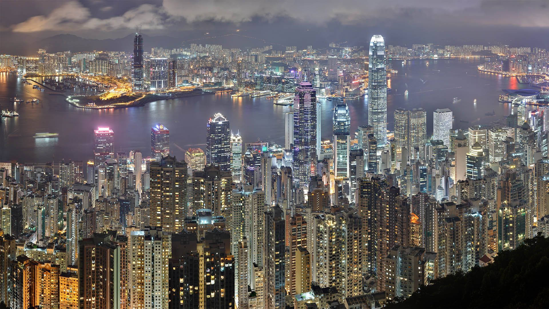 夜間香港天際線，燈火通明的摩天大樓和港口燈光。