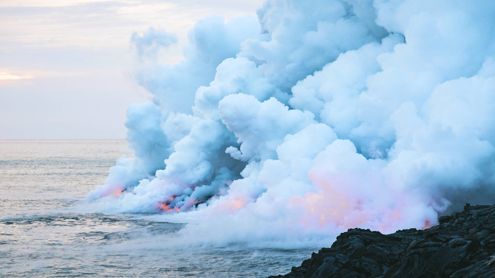 黃昏時分，海洋熔岩流升起的火山蒸氣和煙霧