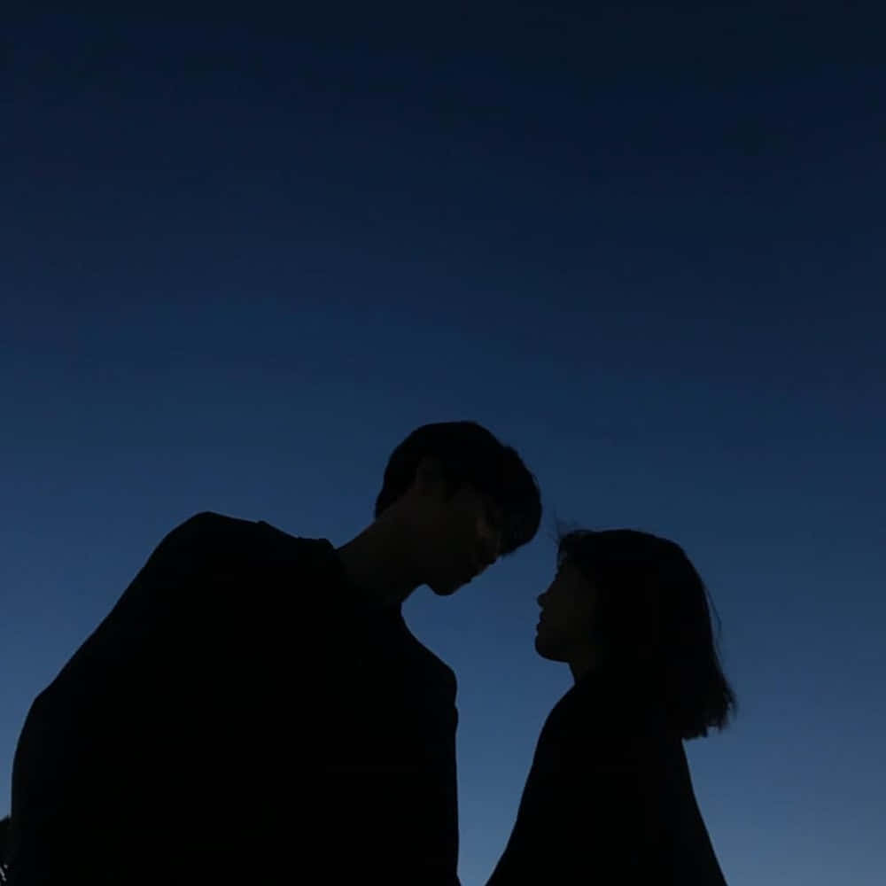 夜空情侶剪影圖 壁紙 — 一對情侶在深暮色天空下互相凝視的剪影。