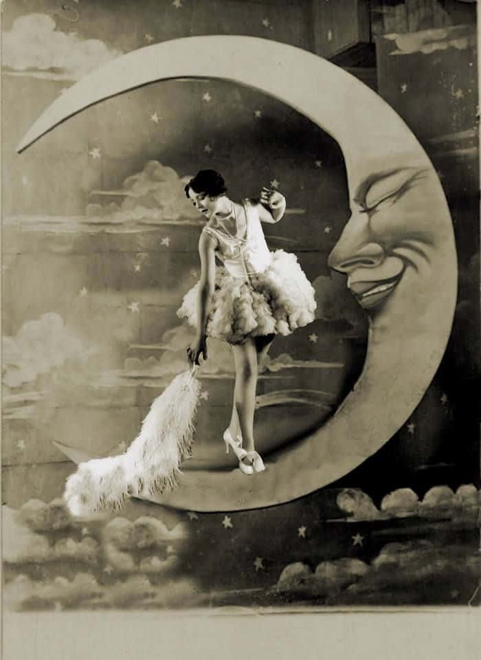 夜空的神秘之美 壁紙 — 一張復古懷舊的棕褐色調照片，一名穿著蓬鬆芭蕾舞裙的女子站在微笑的彎月上，背景是星空。