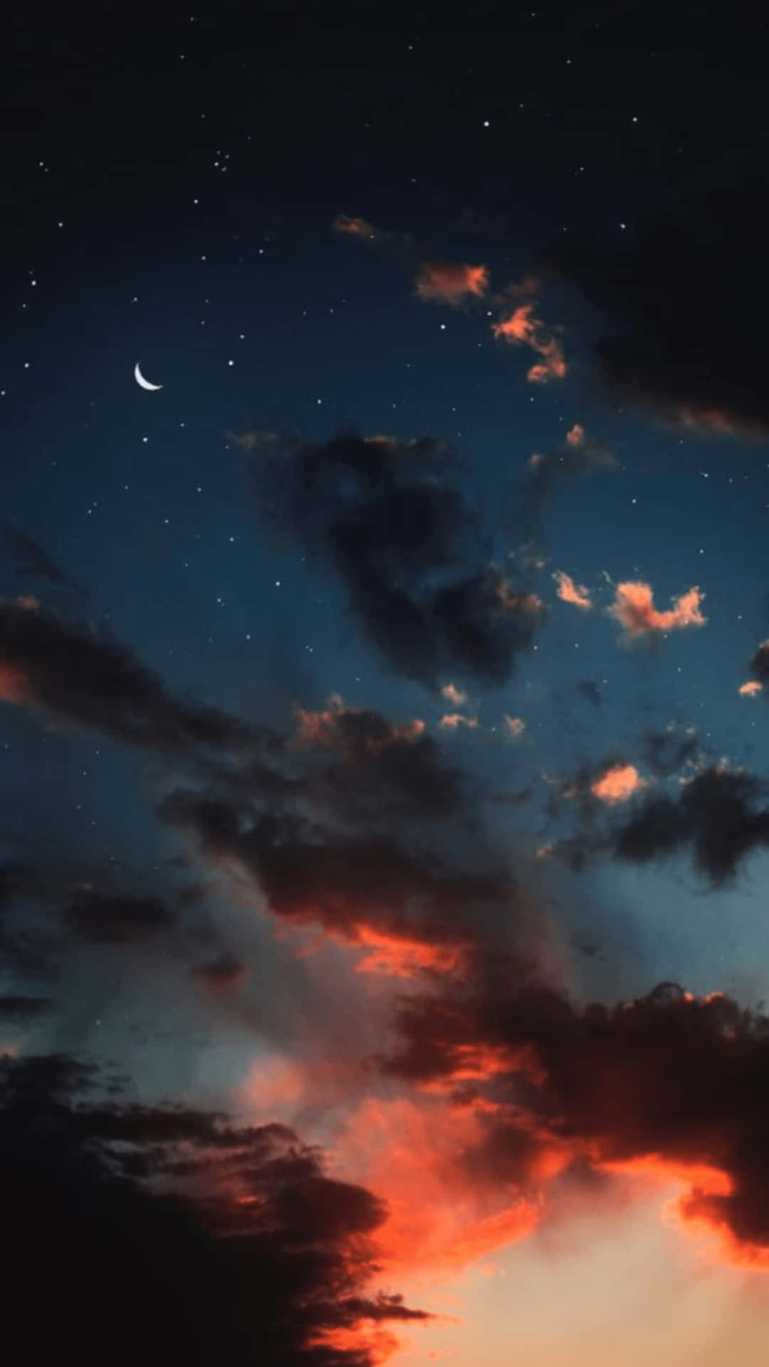 火橙色和藍色暮光雲層上方的新月和星星。