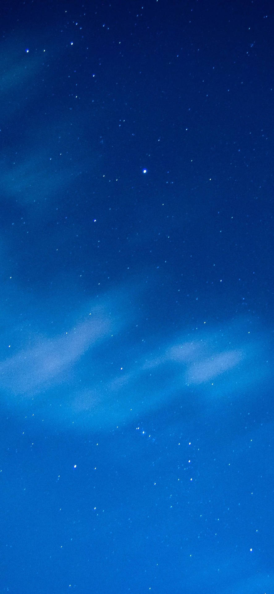 繁星點點的夜空，柔軟的雲朵在深藍色天空中飄動。