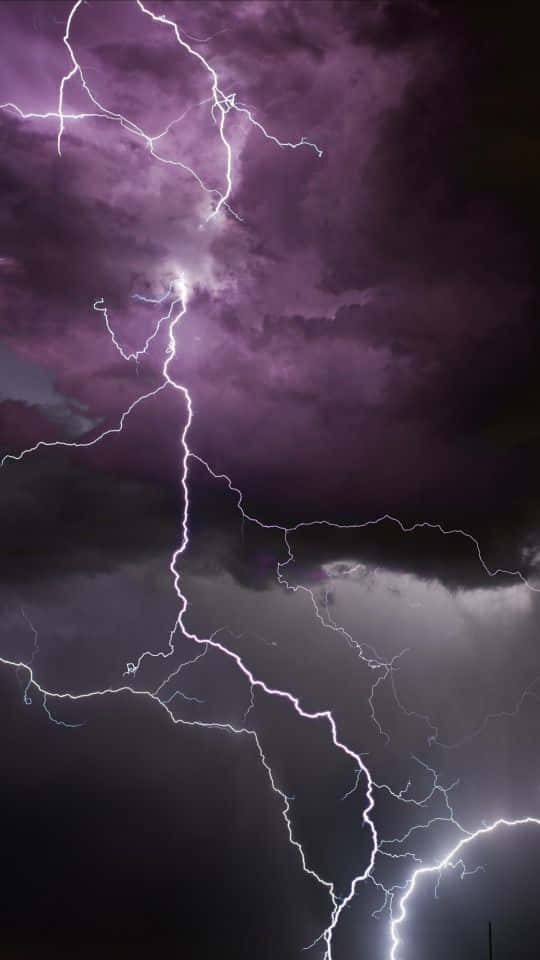 明亮的閃電照亮了紫色的暴風雨雲。