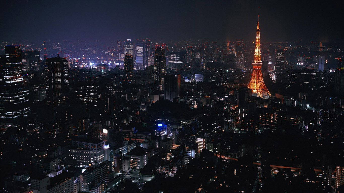 夜間東京城市景觀，東京塔在摩天大樓中亮起。