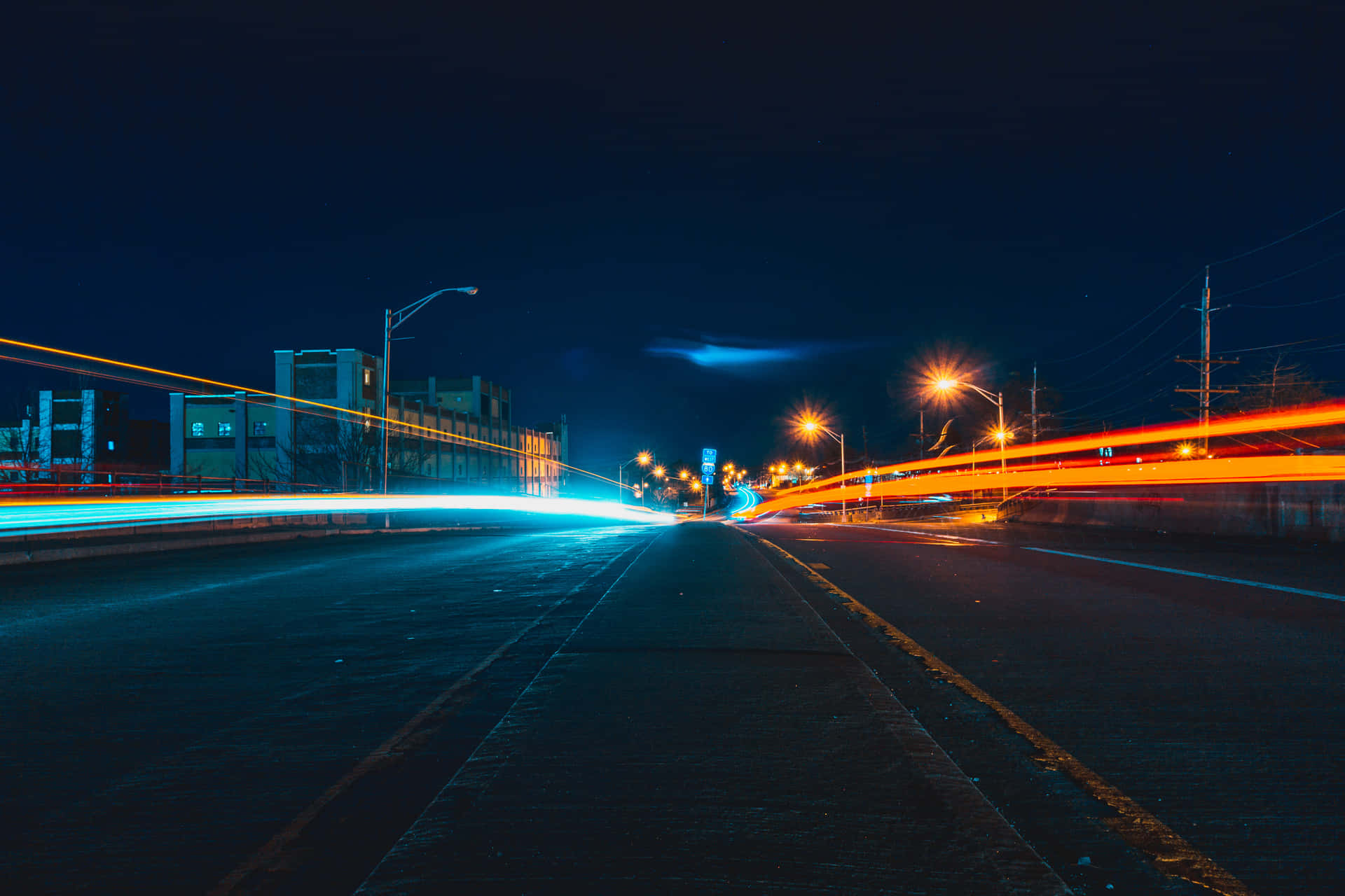 夜間高速公路，帶有藍色和橙色車輛燈光條紋。