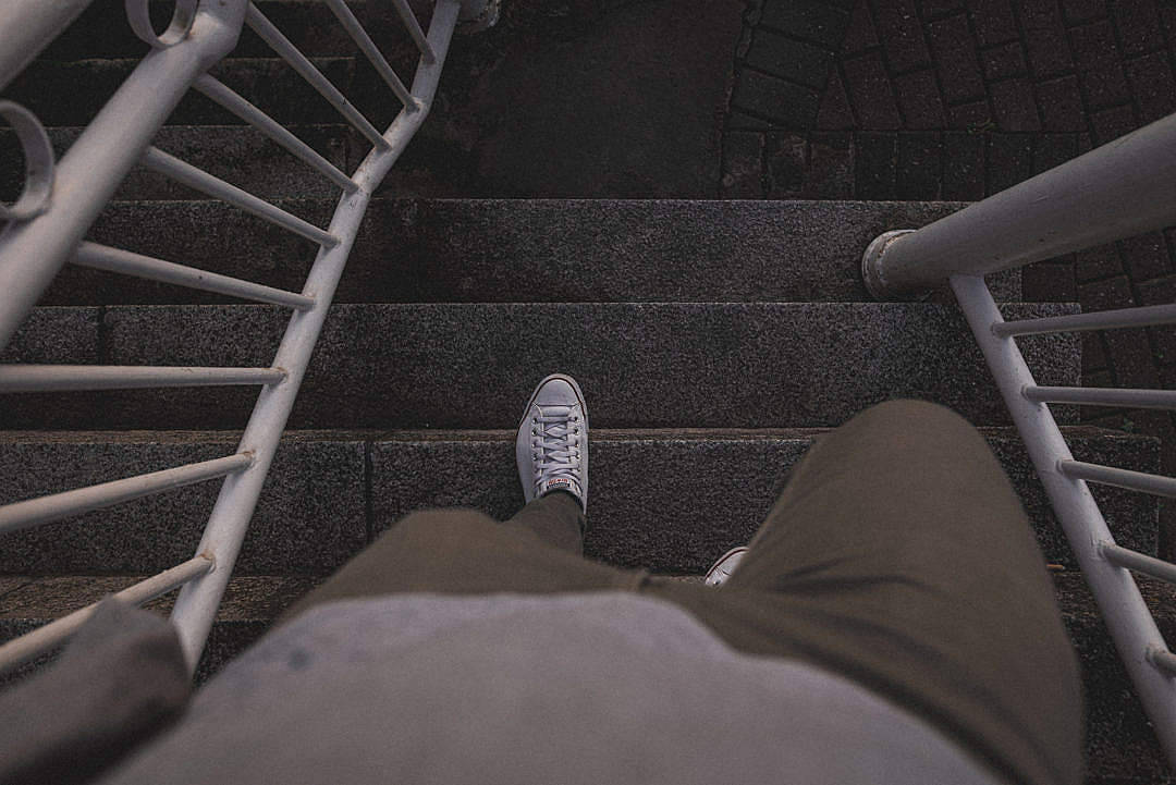 夜行孤人 壁紙 — 第一人稱視角，有人穿著白色運動鞋，攀爬兩側有白色金屬欄杆的深色石階。