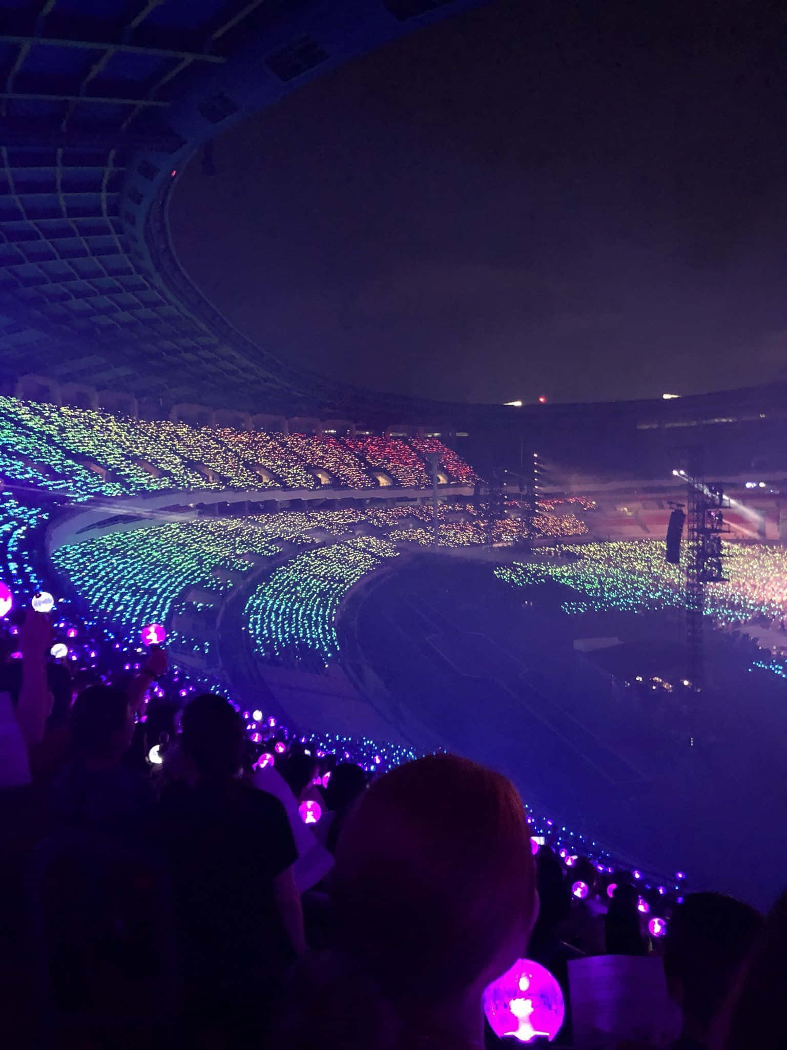 Bts Army Bomb 桌布 壁紙 — 夜間一個巨大的體育場，充滿了揮舞著發光螢光棒、形成鮮豔圖案的粉絲。