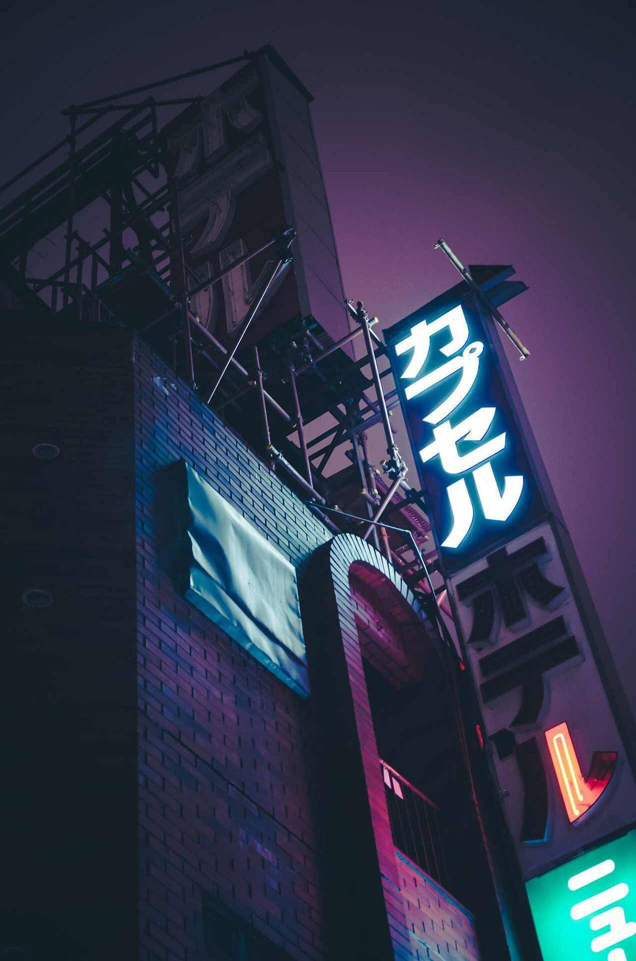 夜間霓虹酒店招牌在磚砌建築上發光。