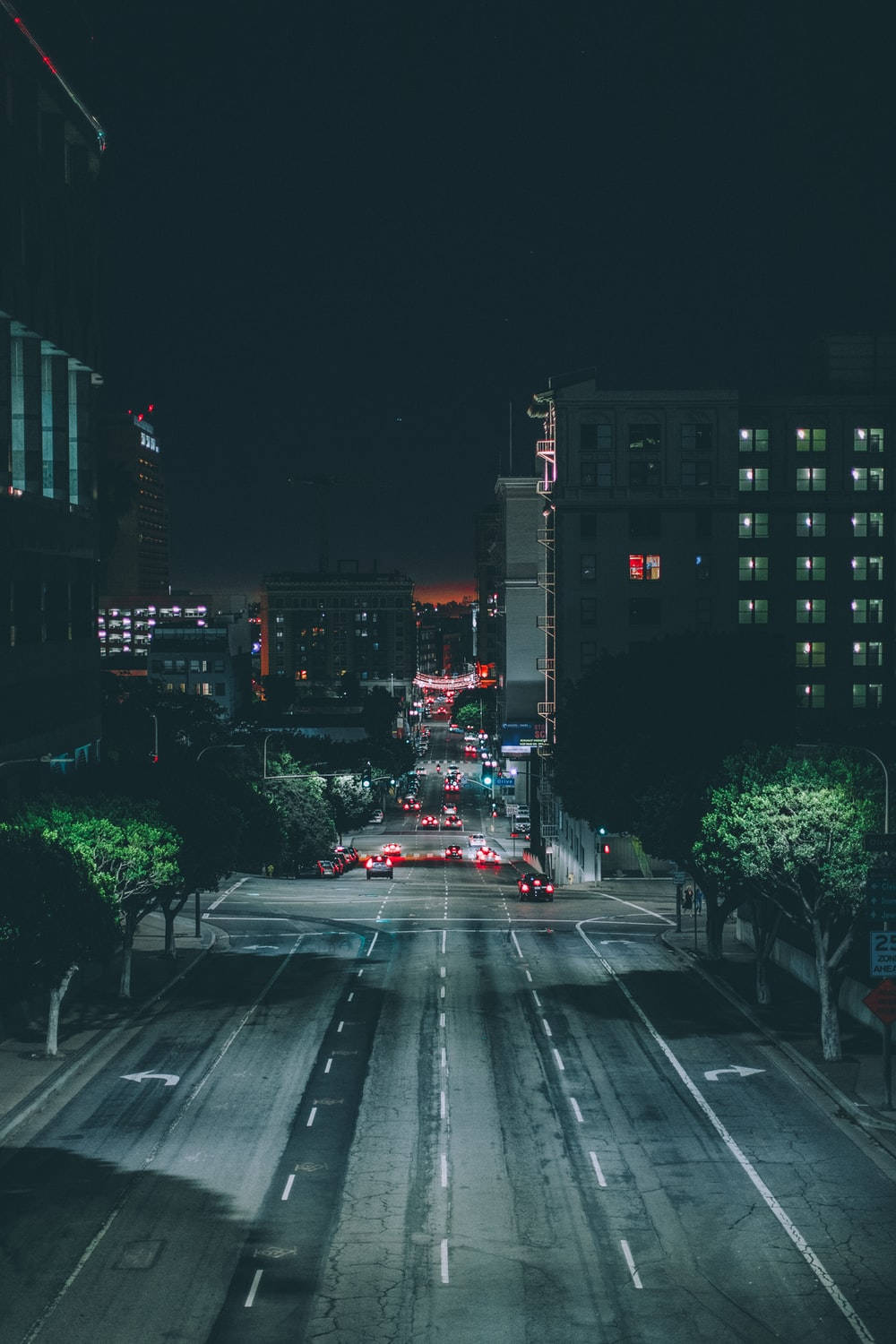 夜間暗城 壁紙 — 從上方俯瞰的夜間城市街道，有發光的車燈和沿路照明建築物。