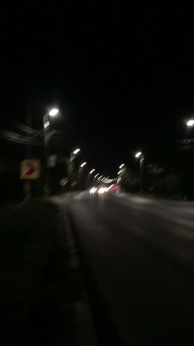 夜間街道場景，街燈和車頭燈呈現動態模糊效果。