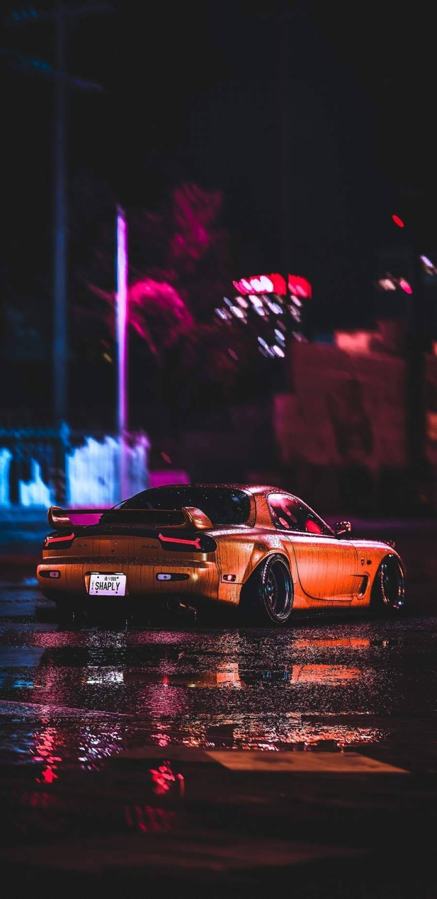 金色跑車在濕漉漉的街道上反射夜間霓虹燈光。