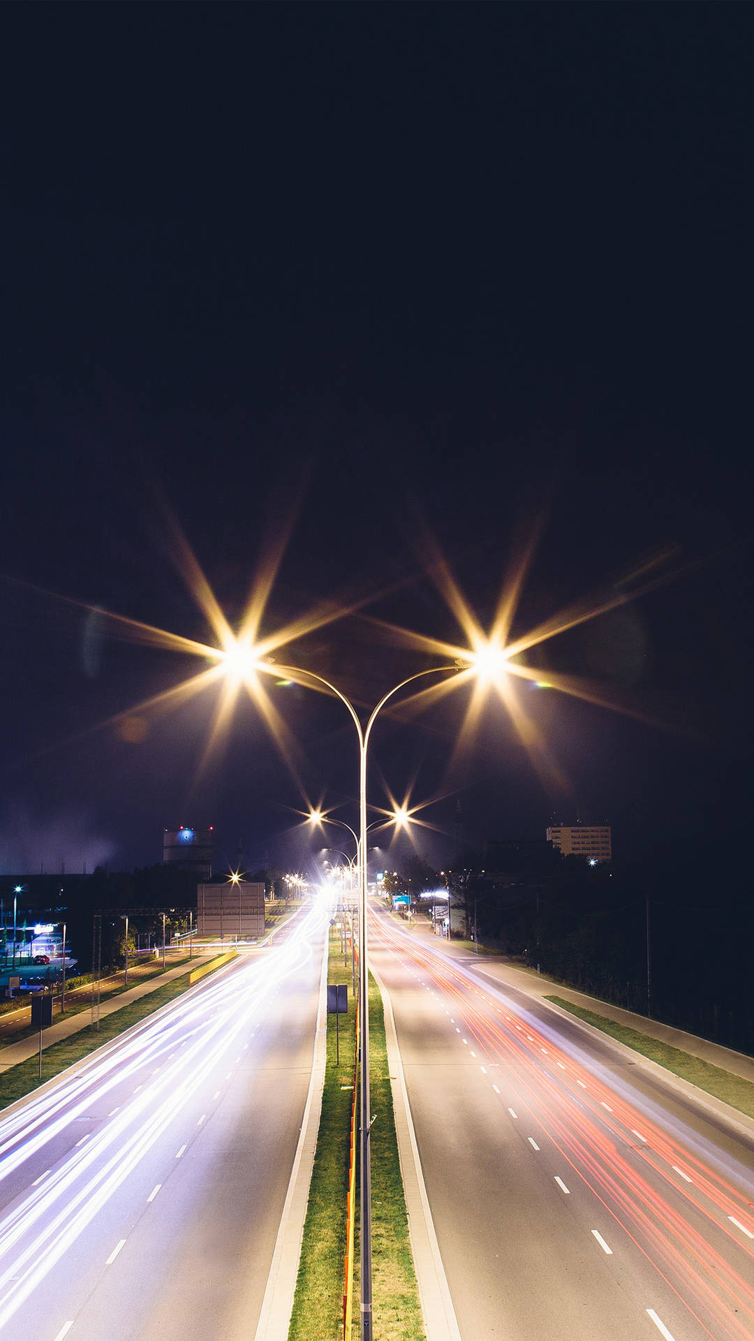夜間高速公路，車燈光軌和發光路燈。