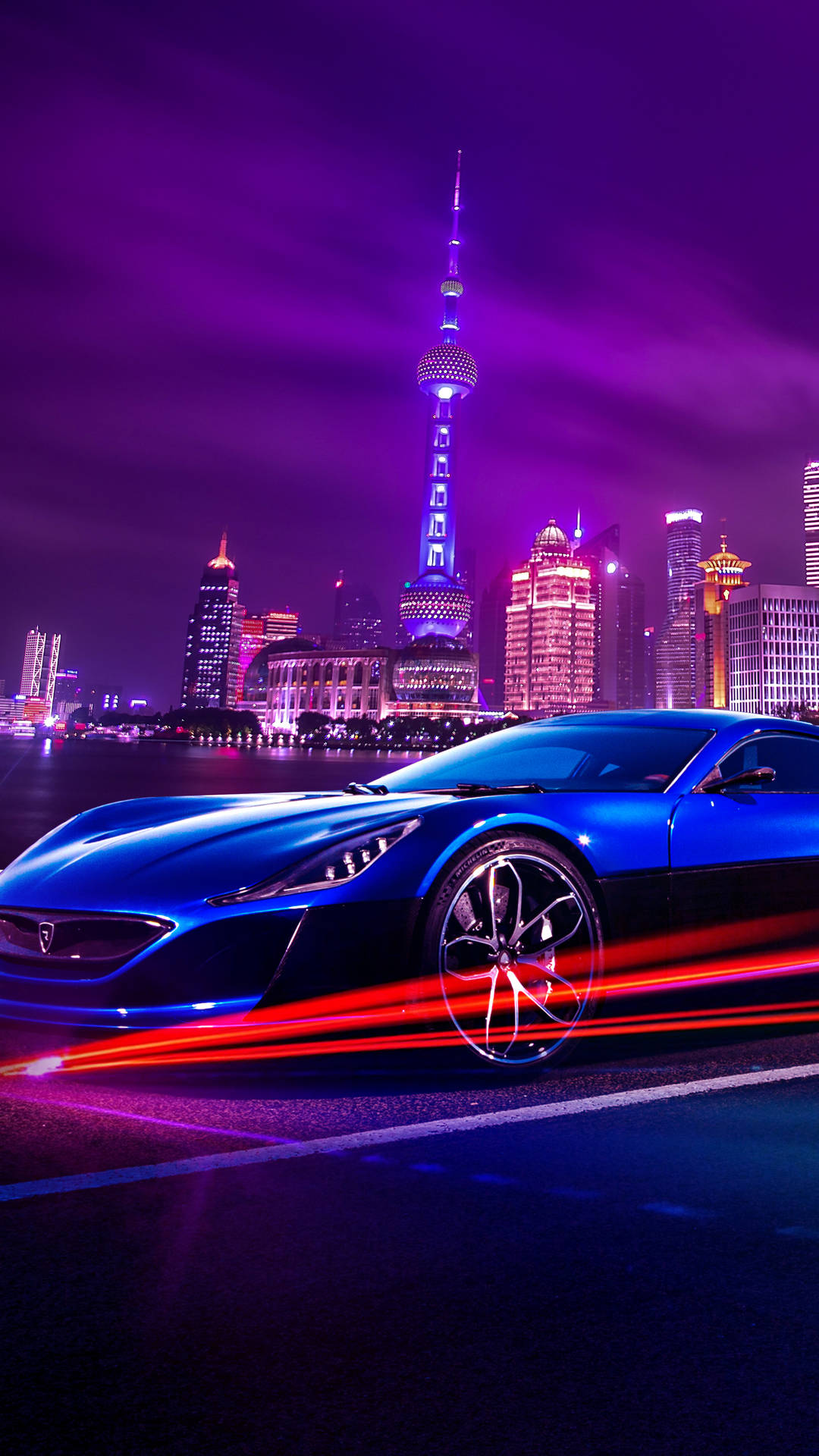 藍色跑車在霓虹閃爍的上海夜間飛馳，留下光軌。