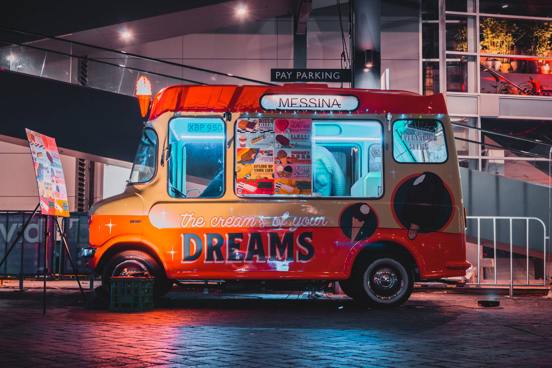 一輛色彩鮮豔的冰淇淋車在夜晚停放在城市環境中。
