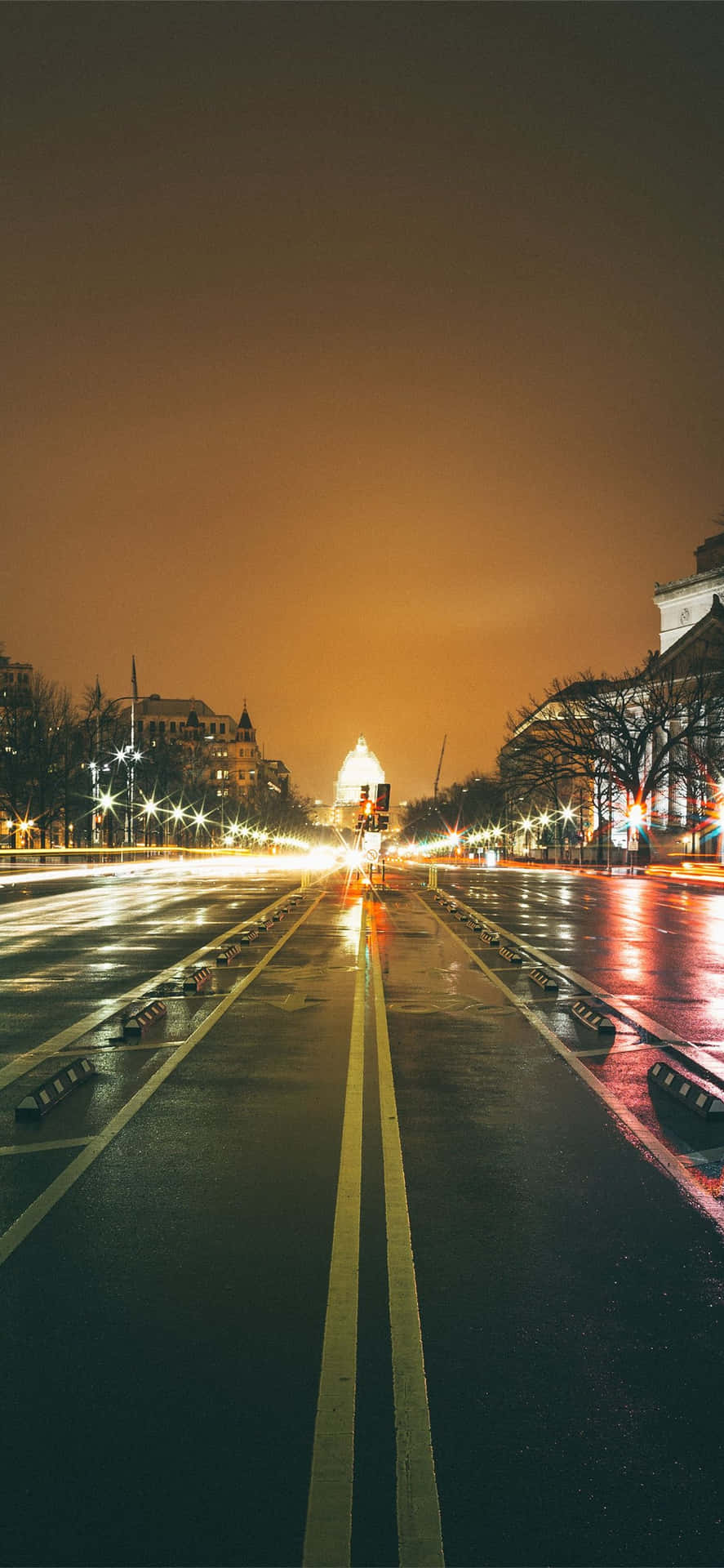 夜晚濕漉漉的城市街道，閃爍的路燈和模糊的車燈。