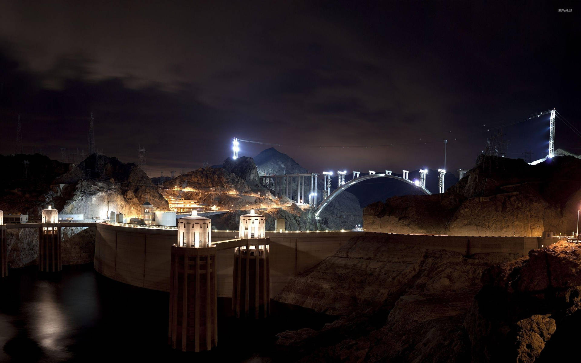 夜晚在沙漠峽谷中的照明水壩和拱橋。
