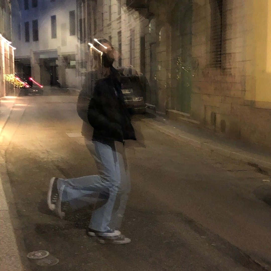 夜晚在昏暗的城市街道上行走的人，帶有動態模糊效果。