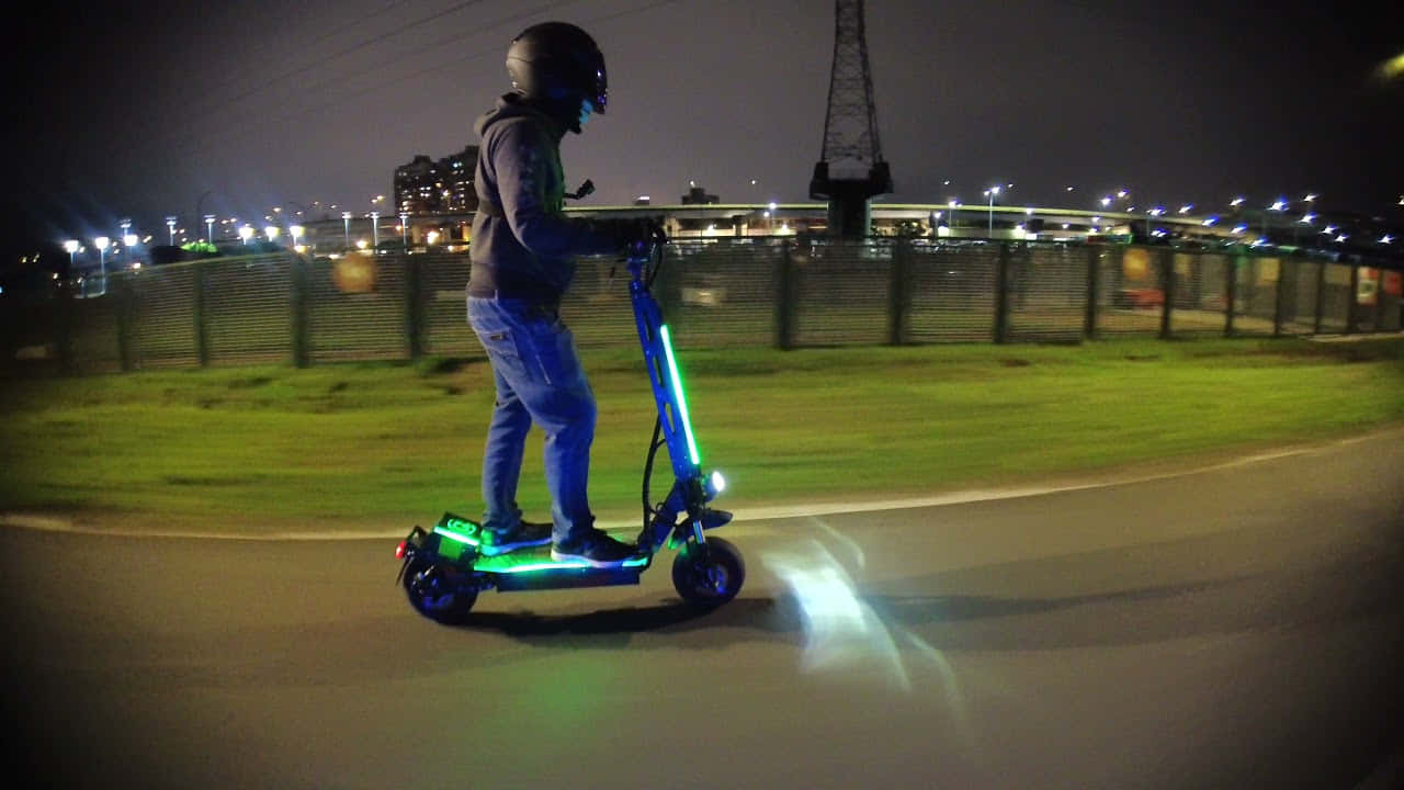 夜間在城市環境中騎著發光電動滑板車的人