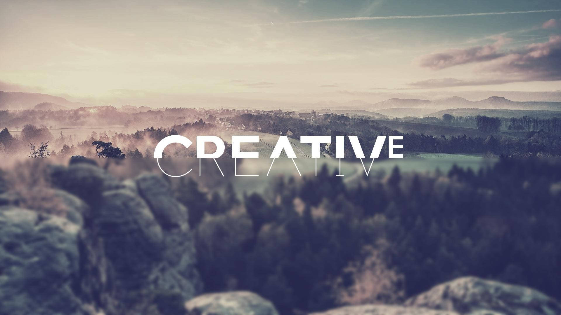 黎明時分霧氣瀰漫的山景，帶有「CREATIVE」文字覆蓋。