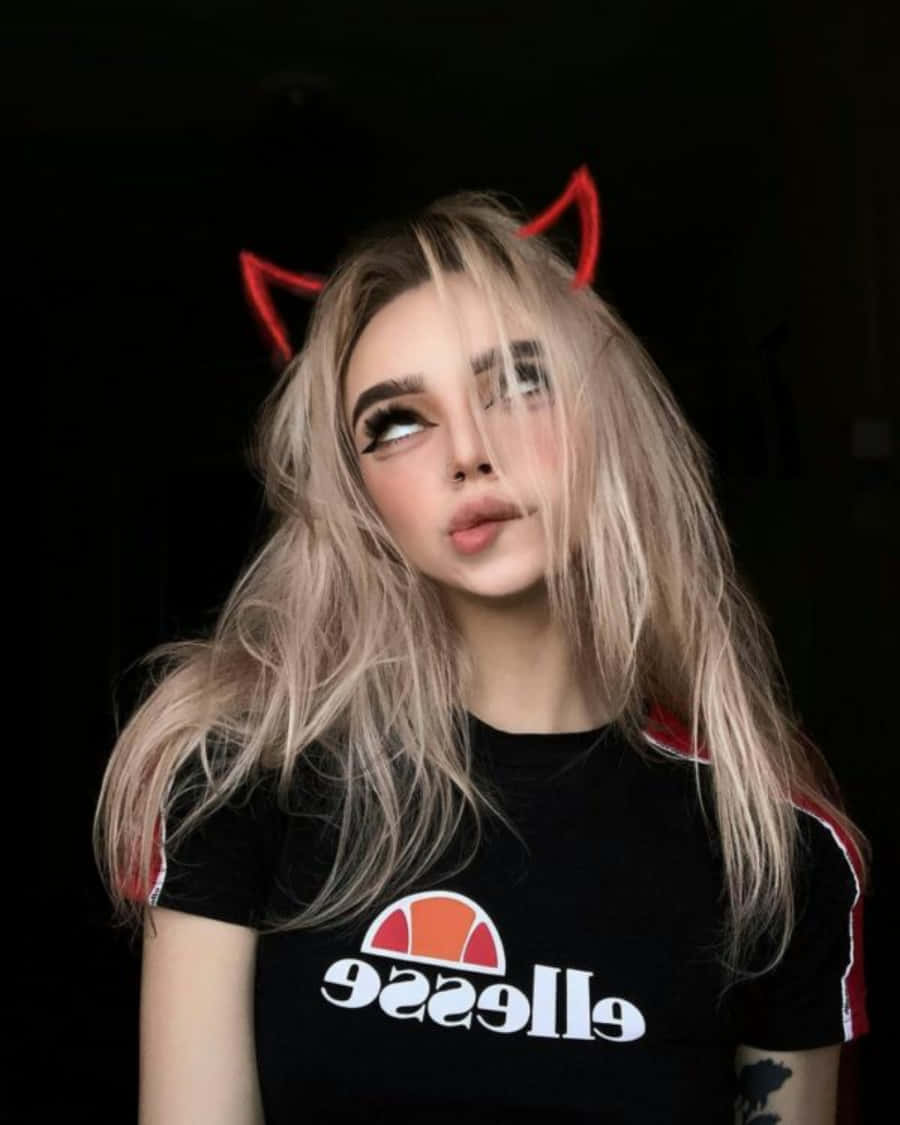 金髮紅惡魔角的年輕女性身穿黑色Ellesse T恤。