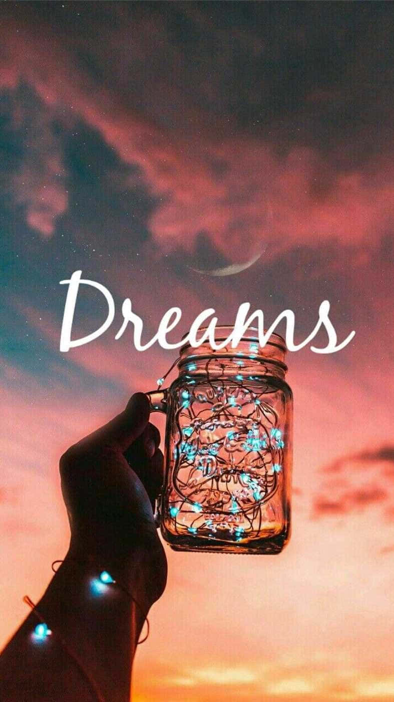 手拿著發光燈的瓶子，背景是帶有新月和Dreams字樣的暮色天空。