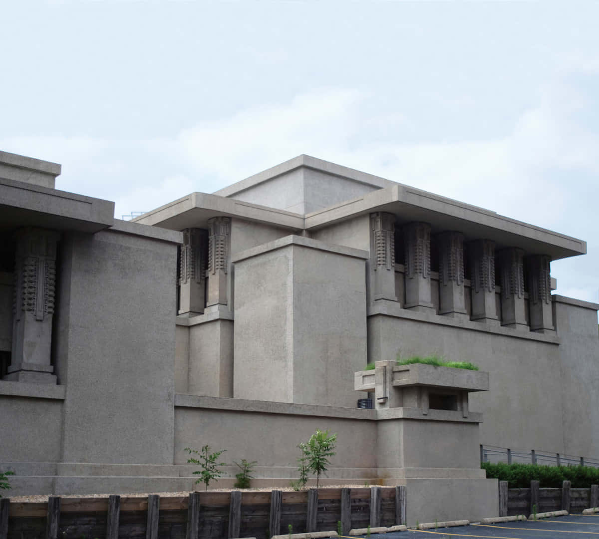 大型混凝土建築圖片 壁紙 — 一座灰暗的混凝土建築，具有幾何線條和垂直百葉窗，在陰天天空下。