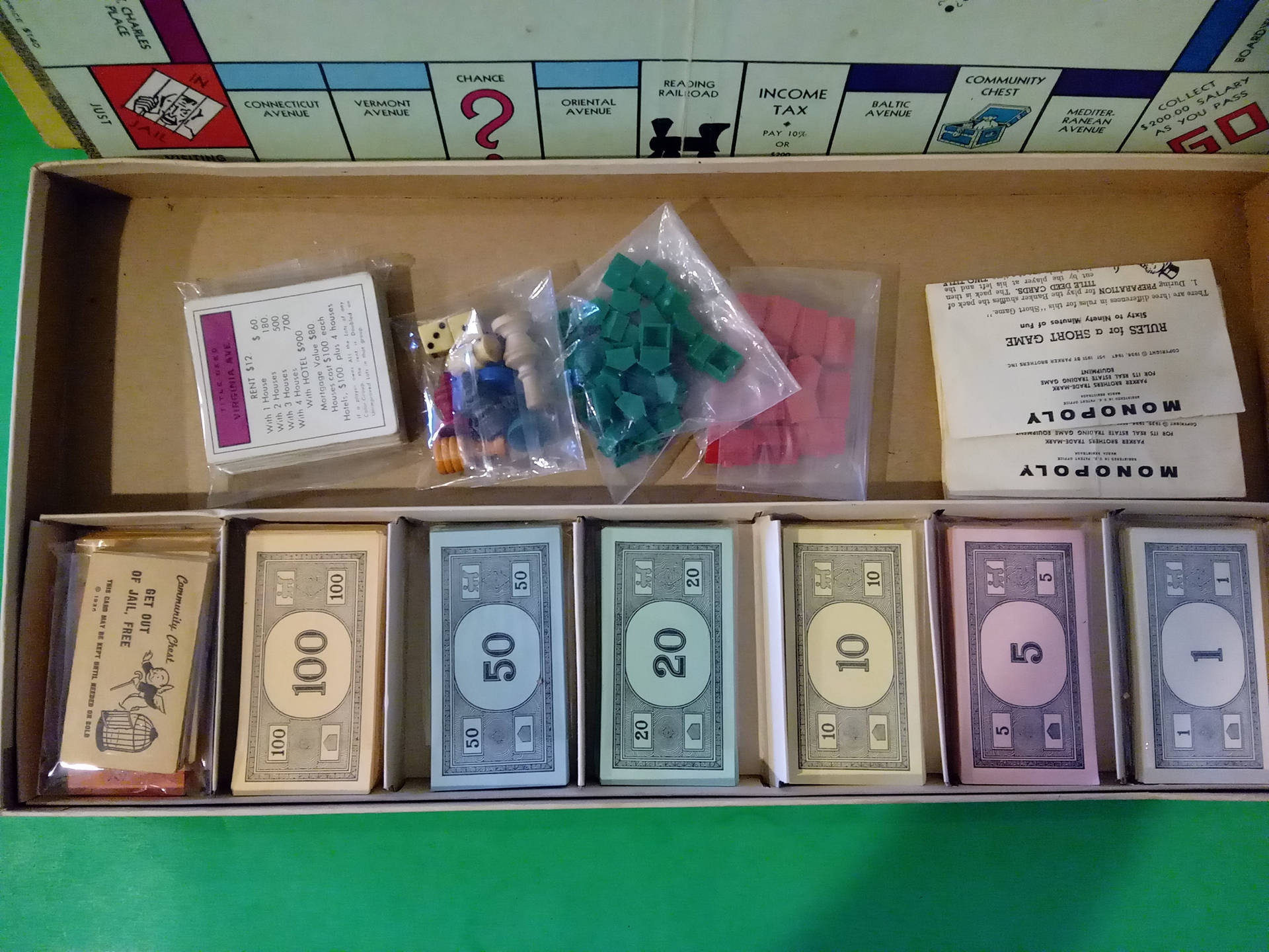 復古大富翁遊戲組件整齊地排列在原裝盒中。
