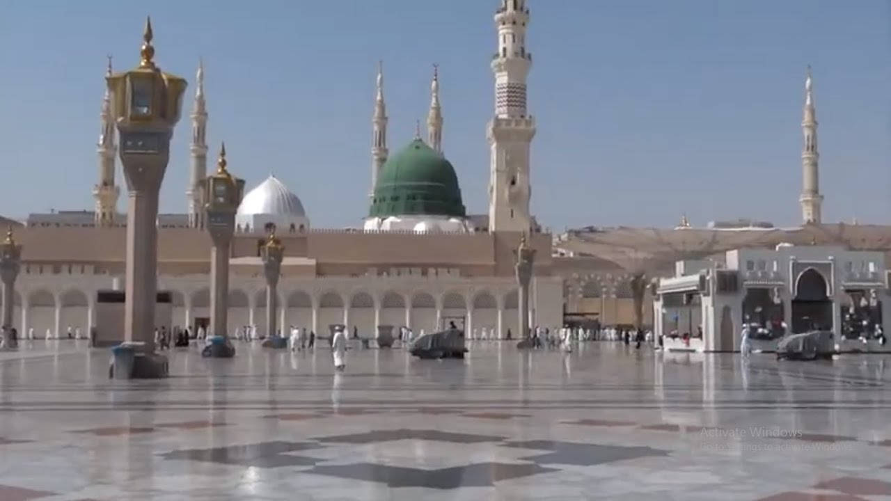 Madina Sharif 桌布 壁紙 — 大清真寺，綠色圓頂和宣禮塔，在晴朗藍天下倒映在拋光大理石庭院中。