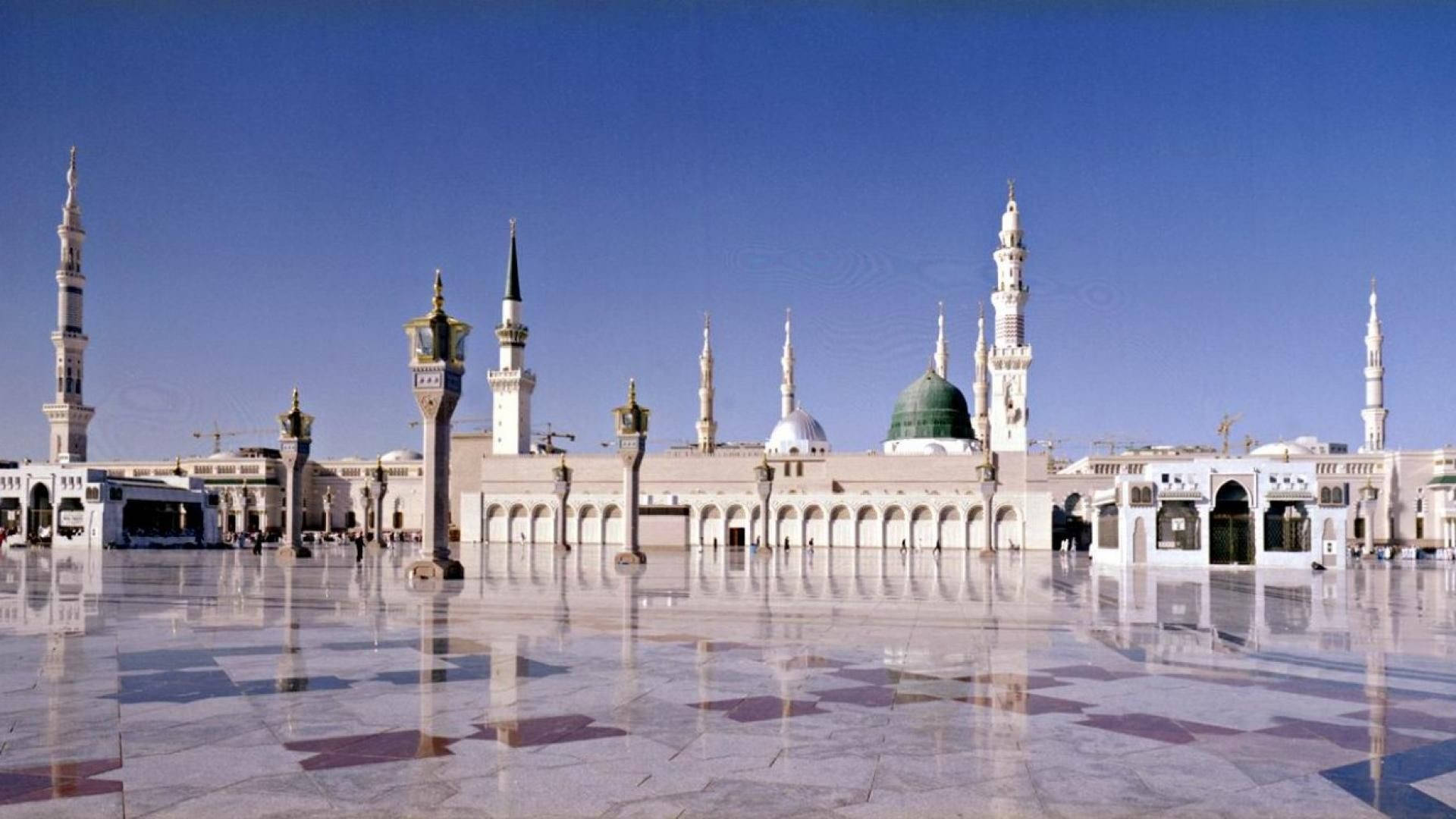 Madina Sharif 桌布 壁紙 — 大清真寺，綠色圓頂和宣禮塔倒映在拋光大理石庭院中，天空清澈湛藍。