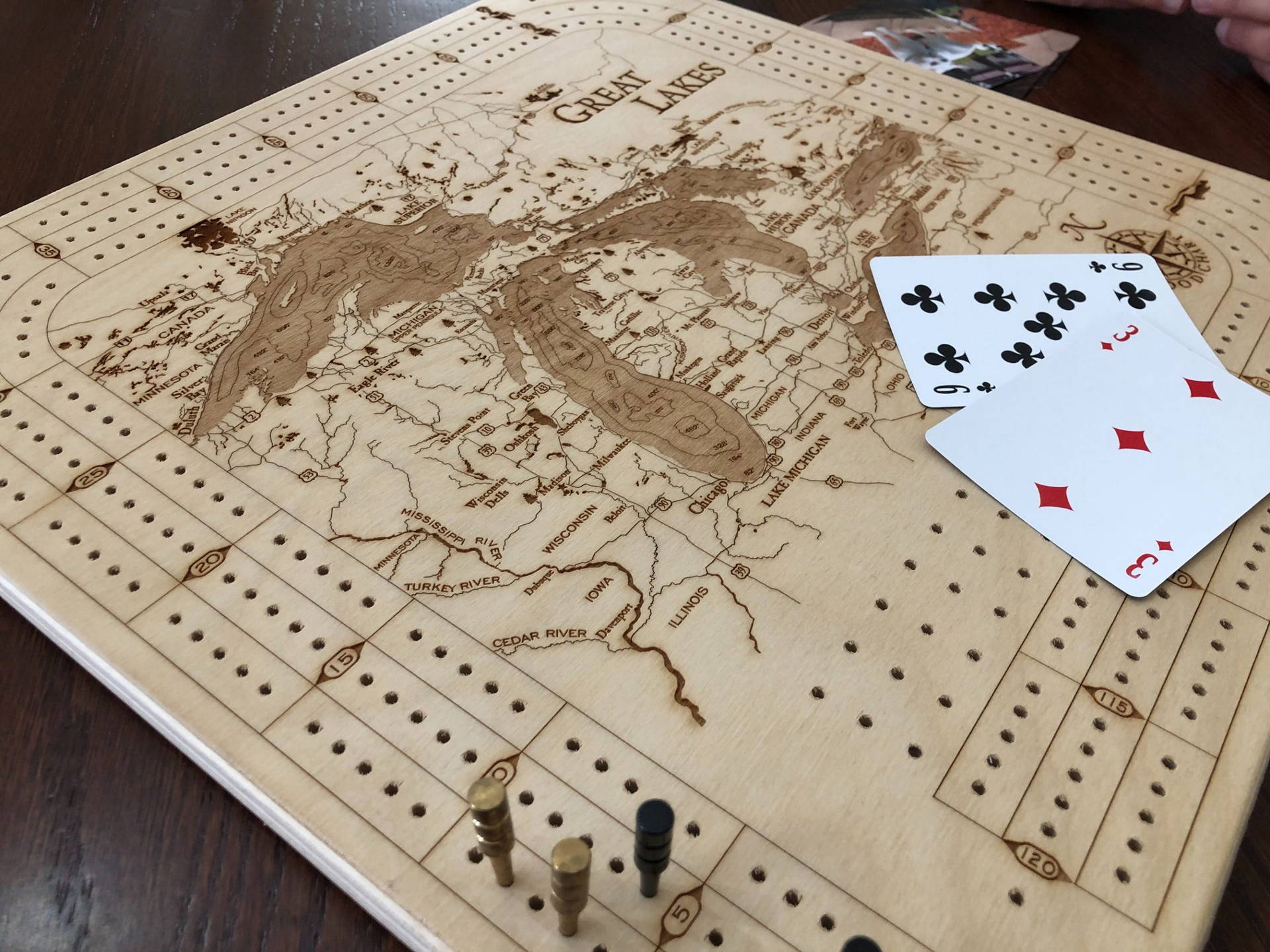 木桌上帶有五大湖地圖和撲克牌的克里比奇棋盤。