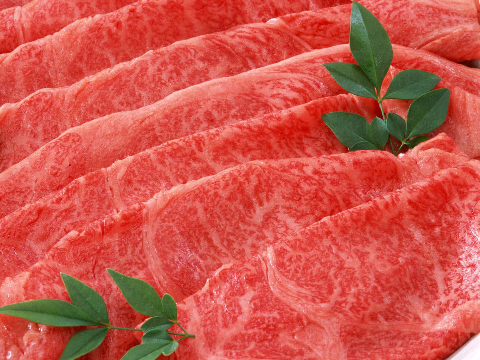Red Meat 桌布 壁紙 — 大理石紋牛肉片配綠葉，以特寫食物擺盤方式呈現。