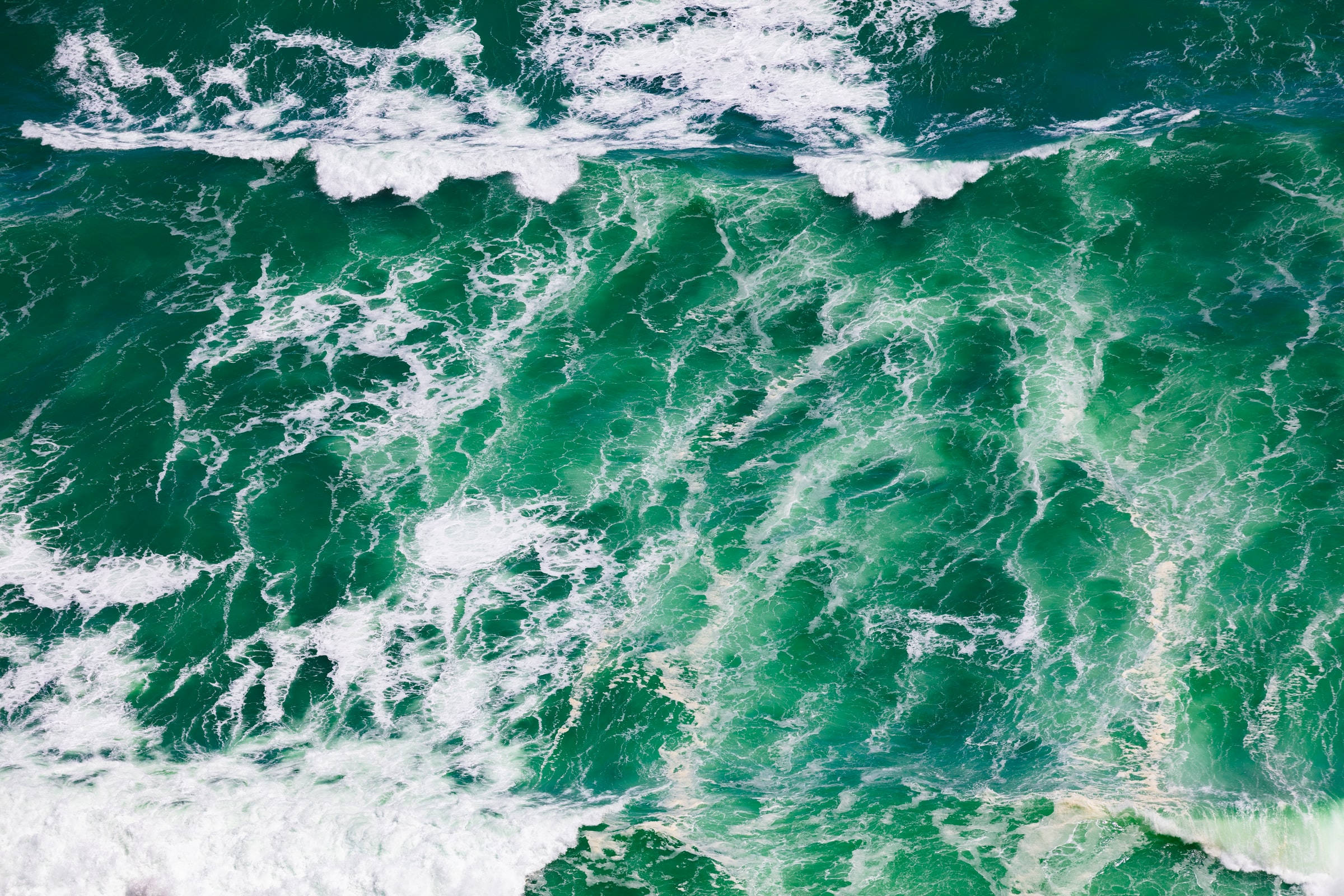 大理石紋理的海洋藍色海浪 壁紙 — 從空中俯瞰，洶湧的祖母綠海浪撞擊出白色泡沫，呈現動態運動。