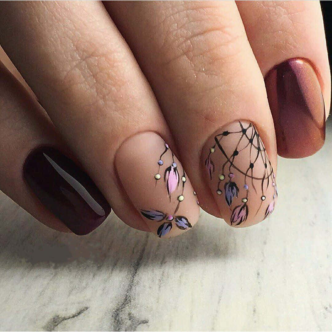 Spring Nails 桌布 壁紙 — 大理石表面上精緻美甲的特寫，帶有細膩花卉設計和金屬點綴。