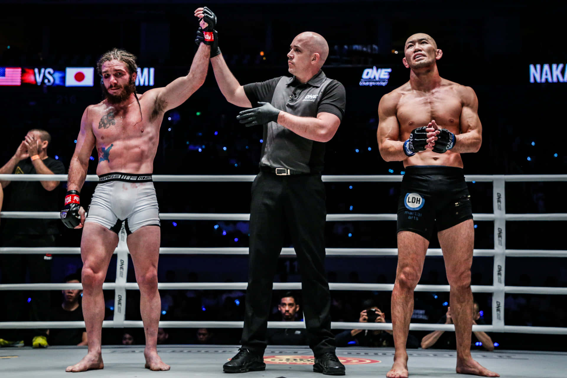 MMA拳手贏得比賽，裁判在八角籠中舉起他的手。