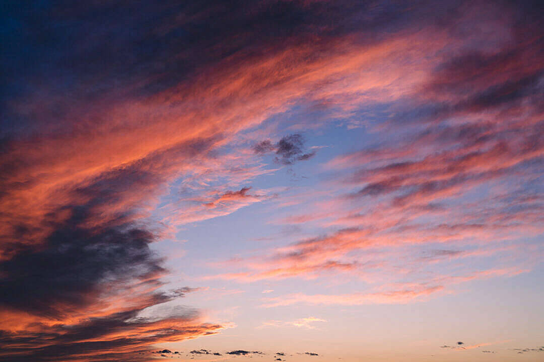 大積雲與夕陽天空美學壁紙 壁紙 — 戲劇性的日落雲彩以火熱的橙色和深紫色色調劃過黃昏的天空。