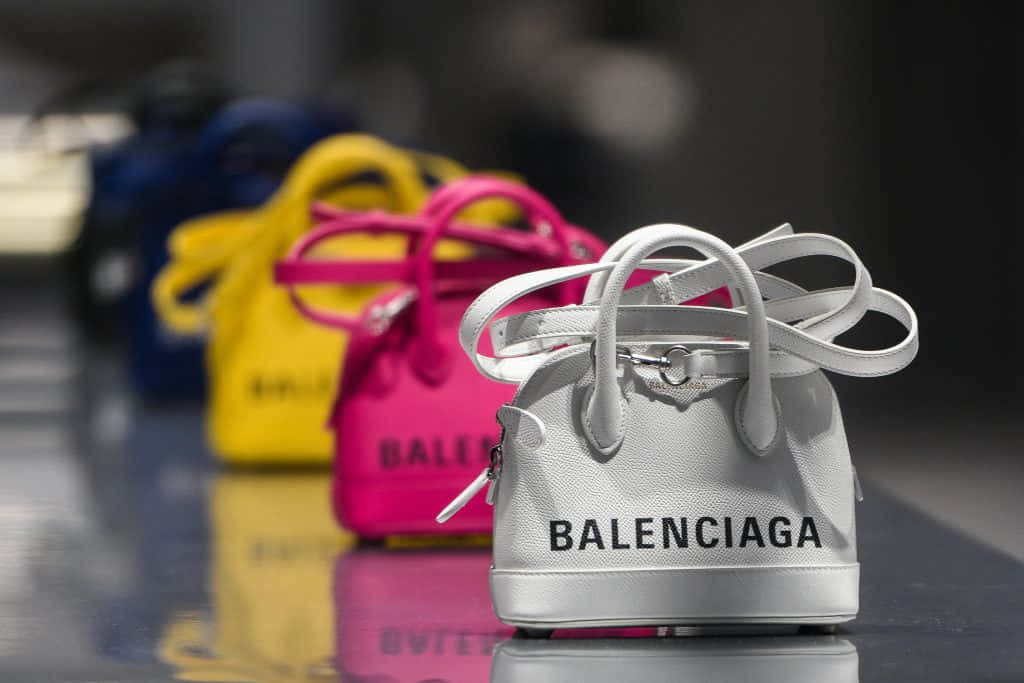 色彩繽紛的Balenciaga手袋在店內展示，拋光地板上反射出倒影。